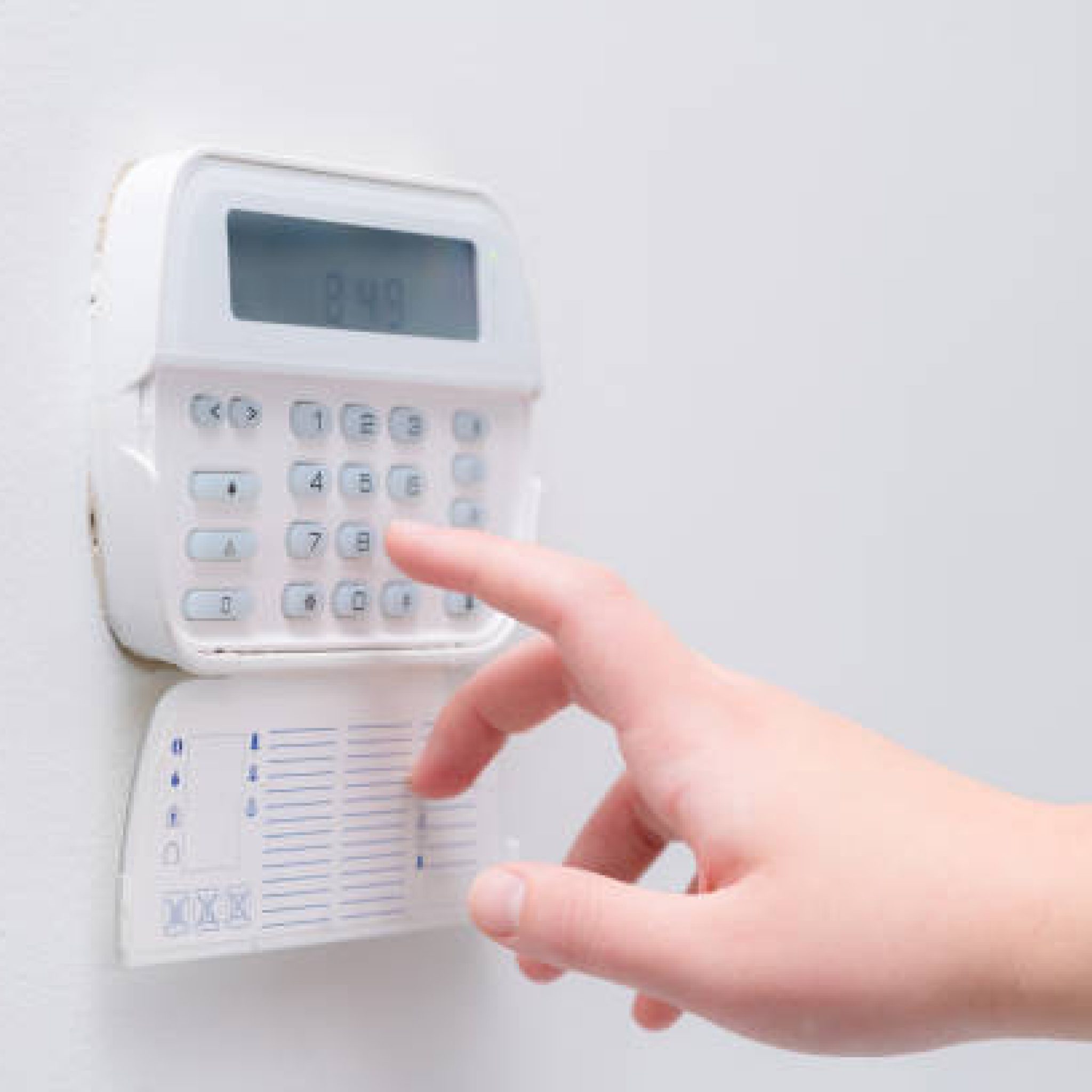 Woman hand entering alarm system password of an apartment, house of business office. Surveillance and protection console against rubbery and thief