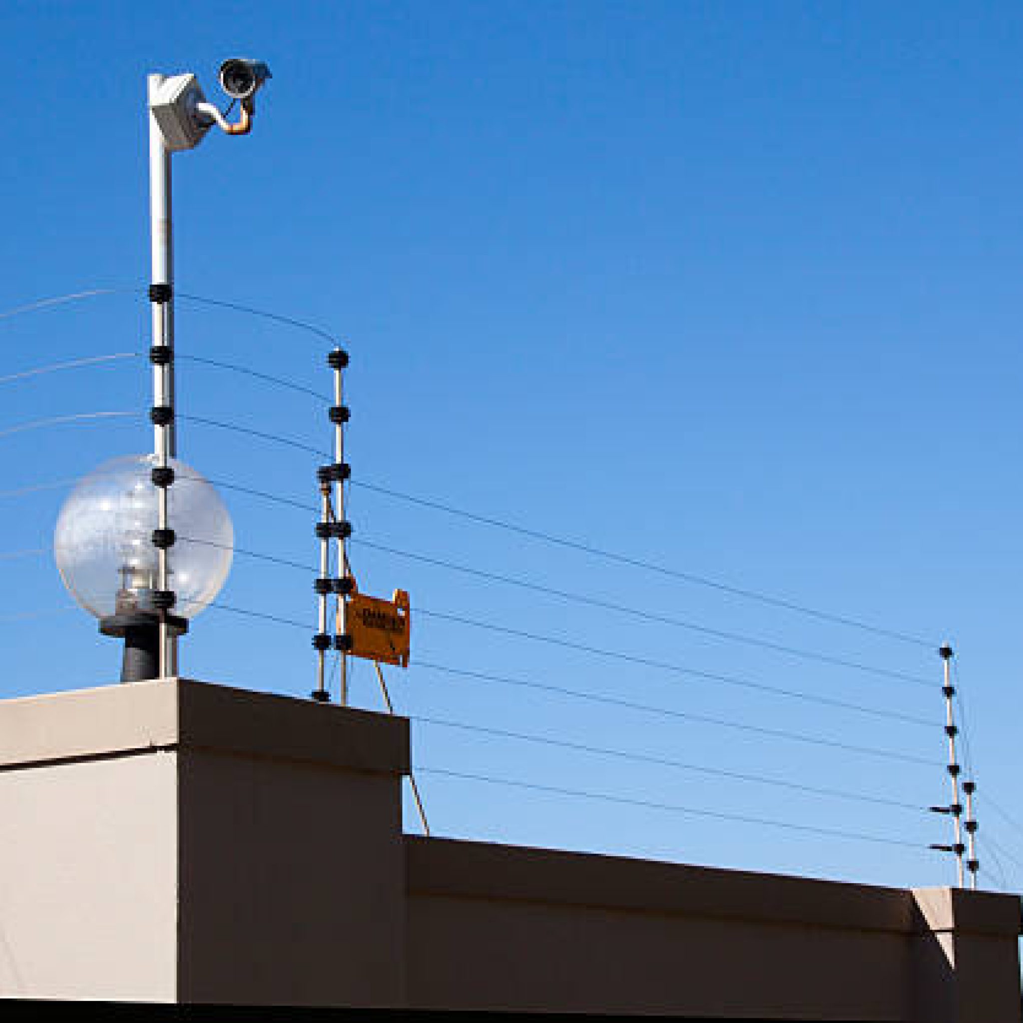 electric fence and security camera atop boundary wall